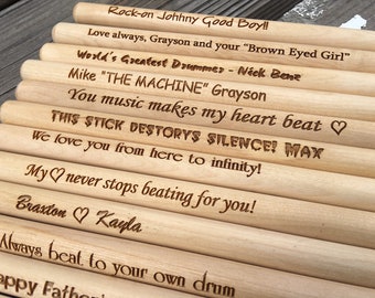 Puede incluir: Un conjunto de baquetas de batería de madera con mensajes personalizados grabados en ellas. Los mensajes incluyen "Rock-on Johhny Good Boy!" "Love always, Grayson and your "Brown Eyed Girl" "World's Greatest Drummer - Nick Bene" "Mike "THE MACHINE" Grayson" "You music makes my heart beat" "THIS STICK DESTORYS SILENCE! MAX" "We love you from here to infinity!" "My heart never stops beating for you!" "Braxton Kayla" "Always beat to your own drum" "Happy Father's Day"