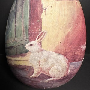 Egg shaped chocolate box with hand painted image of a detailed white bunny rabbit next to a doorway