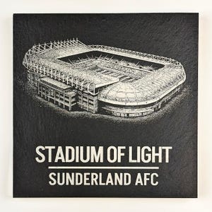 Puede incluir: Un posavasos cuadrado de pizarra negra con una ilustraci&oacute;n blanca grabada del Stadium of Light. El texto "STADIUM OF LIGHT" aparece sobre una l&iacute;nea horizontal, con "SUNDERLAND AFC" impreso debajo en una fuente blanca sin remates.