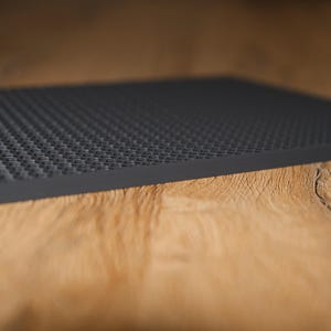 May include: A black Lego baseplate with a textured surface.