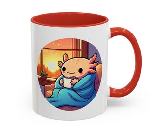 May include: A white ceramic mug with a red rim and handle. The mug features a cartoon illustration of an axolotl sitting in a chair by a window, wrapped in a blue blanket and holding a cup of coffee. The background is a sunset scene.