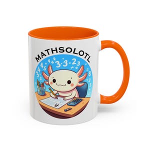 May include: White ceramic mug with an orange rim and handle. The mug features a cartoon axolotl wearing a blue shirt and holding a pencil. The axolotl is sitting at a desk with a calculator and a piece of paper with maths equations. The text "MATHSOLOTL" is written in a circle around the axolotl.