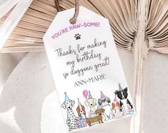 Pode incluir: Uma etiqueta de agradecimento branca com texto rosa e azul que diz "You're Paw-some!" e "Thanks for making my birthday so doggone great!" com uma pegada de pata e o nome "Ann-Marie". A etiqueta apresenta uma ilustração de desenho animado de sete cães com chapéus de festa.