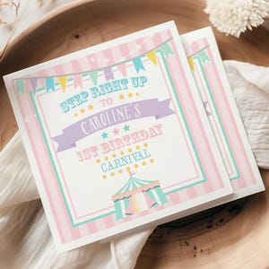 May include: Two square invitations with a pastel pink and blue striped border, featuring text that reads "Step Right Up to Caroline's 1st Birthday Carnival." The design includes a circus tent illustration and colorful bunting. The invitations are arranged on a wooden plate with a white cloth.