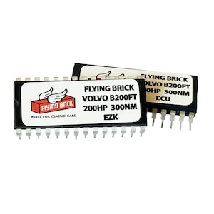 Könnte beinhalten: Zwei schwarze elektronische Steuergeräte (ECUs) mit weißem Text. Die ECUs tragen die Aufschrift "FLYING BRICK" und "VOLVO B200FT 200HP 300NM EZK". Das Flying Brick-Logo zeigt einen roten Ziegelstein mit weißen Flügeln. Die ECUs haben mehrere Pins.