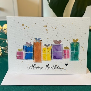 Cartão de aniversário com presentes coloridos - desenho em aquarela pintado à mão