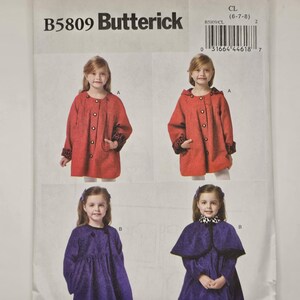 May include: A Butterick sewing pattern, B5809, featuring four images of children's coats. Two red coats with leopard print cuffs and two purple coats, one with a cape. The pattern size is CL (6-7-8).