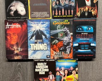 May include: A collection of nine VHS tapes featuring horror and sci-fi movies. The tapes include titles like "Scary as Hell", "House II", "The Faculty", "Dracula", "Apocalypse Now", "The Thing", "Godzilla", "Christine", and "Scary Movie".