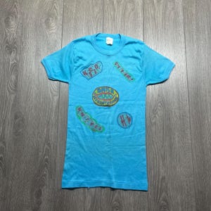 Maglietta grafica vintage anni &#39;70 fatta a mano con sorriso blu carino, aderente, con punto singolo