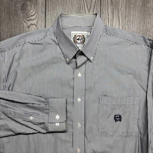 Puede incluir: Camisa a rayas azul marino y blanca con cuello abotonado. La camisa tiene un bolsillo en el pecho con un logotipo bordado y puños abotonados. Las mangas largas tienen puños abotonados. Fabricada en tejido ligero.