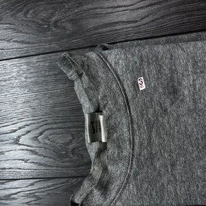 Puede incluir: Una camiseta gris de cuello redondo con una etiqueta que dice "Nike Sports Car Costa". Tambi&eacute;n es visible una peque&ntilde;a etiqueta blanca con el n&uacute;mero "5K63". La camiseta est&aacute; hecha de un material suave y c&oacute;modo.