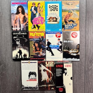 May include: A collection of VHS tapes featuring various movies, including "Private Parts", "Austin Powers", "Cheech & Chong", "Born in East L.A.", "The Untouchables", "Pulp Fiction", "Catch Me If You Can", "Blow", "U2 Rattle and Hum", "Scarface", "Dog Day Afternoon", and "Al Pacino".