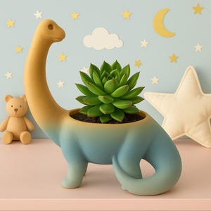 Puede incluir: Una maceta con forma de dinosaurio en tonos amarillo y azul, que contiene una suculenta verde. La maceta es un objeto decorativo, perfecto para añadir un toque de naturaleza a cualquier habitación. El tema general es lúdico y decorativo.