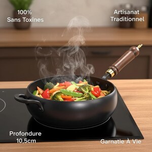 May include: A black wok with a wooden handle, filled with colourful vegetables, steaming on a black stovetop. The wok is labeled with the text "100% Sans Toxines", "Artisanat Traditionnel", "Profondeur 10,5cm", and "Garnatie À Vie". The depth is 10.5cm.
