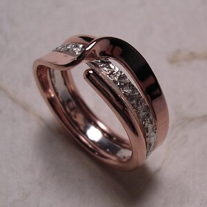 May include: A rose gold and silver intertwined ring with a textured silver band.