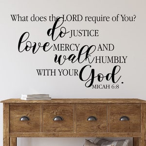 May include: A wall decal with the text "What does the LORD require of You? Do justice, love mercy, walk humbly with your God. Micah 6:8" in black script. The decal is above a wooden console table with drawers.