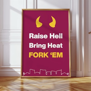 Op de afbeelding: Een ingelijste poster met een gouden rand. De magenta achtergrond toont de tekst "Raise Hell Bring Heat FORK 'EM" in wit en geel. Het ontwerp bevat gele duivelshoorns en een skyline.