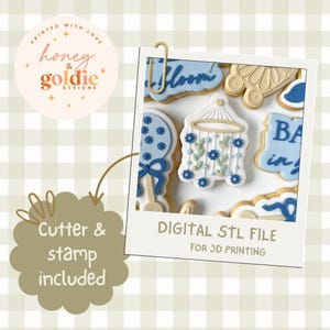 May include: A digital STL file for 3D printing, featuring baby-themed cookies. The cookies are decorated with blue and white icing, including a rattle, a mobile, and the word "Bloom". The image includes the text "Cutter & stamp included".