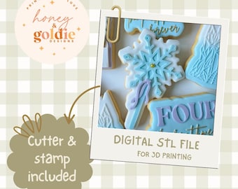 May include: A digital STL file for 3D printing, featuring snowflake and number-shaped cookie cutters. The cookies are decorated with light blue and white icing. The image includes the text "Cutter & stamp included."