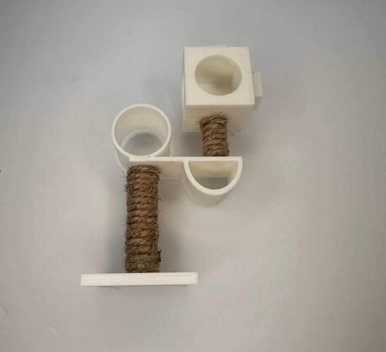 May include: White cat scratching post with two platforms and a sisal rope covered post.