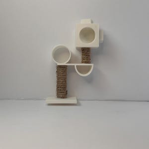 May include: White cat tree with a round platform, a square platform with a hole, and a sisal rope scratching post.