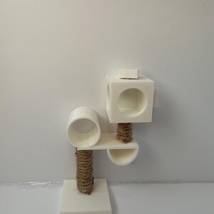 May include: White cat tree with a round platform, a square platform, and a rope scratching post. The cat tree has a small, round opening on the top platform.