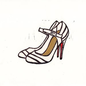 May include: A pair of white heeled shoes with black stripes and a red heel. The shoes have a strap with a buckle.