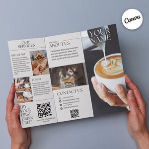 May include: A tri-fold brochure with a black and white design. The front cover features the text "YOUR NAME" in a bold, sans-serif font. The brochure advertises a coffee shop with images of coffee, waffles, and a cafe interior. The brochure also includes a QR code and the text "TRY YOUR FIRST DRINK FREE!"