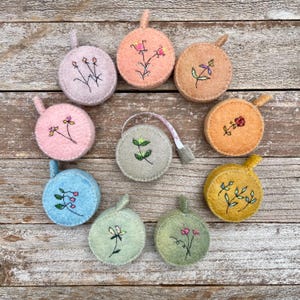 plant-dyed wool felt covered tape measure with botanical stitching, by kata golda