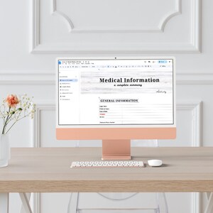 Może przedstawiać: Złoto-różowy komputer iMac wyświetlający dokument zatytułowany „Informacje medyczne: kompletne podsumowanie”. Komputer stoi na jasnym drewnianym biurku z białą klawiaturą i myszą. Po lewej stronie wazon z kwiatami.