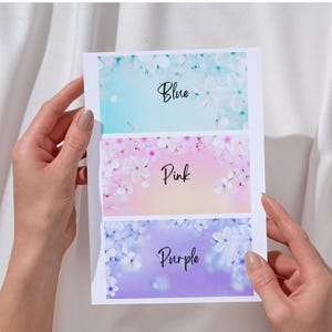 May include: A card with three sections, each with a floral design and a color name. The top section is blue with the word "Blue", the middle section is pink with the word "Pink", and the bottom section is purple with the word "Purple".