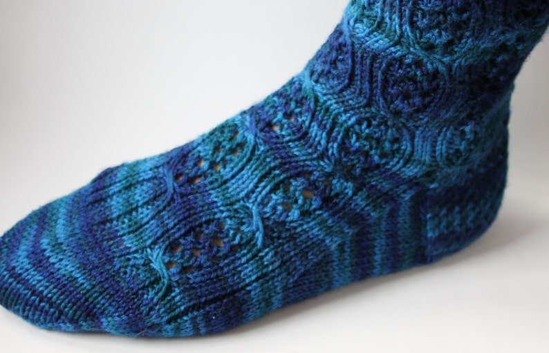 May include: Blue and green striped knitted socks with a lacy pattern.