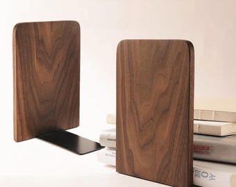 May include: Two wooden bookends with a dark brown finish. The bookends have a rectangular shape with rounded corners and a black metal base. One bookend is holding books, while the other is standing alone.