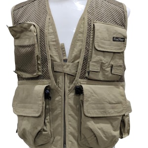 Puede incluir: Un chaleco de pesca de color beige con múltiples bolsillos y un panel trasero de malla. El chaleco tiene una cremallera y un logotipo de Foxfire en el lado derecho.