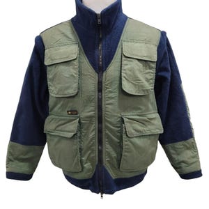 Peut inclure: Une veste en polaire verte et bleue avec plusieurs poches. La veste a une fermeture éclair et un col montant.