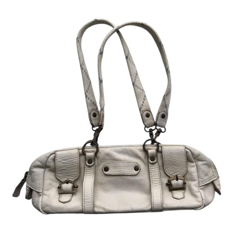 K&ouml;nnte beinhalten: Cremefarbene Lederhandtasche mit zwei Tragegriffen und einer langen, rechteckigen Form. Die Tasche hat zwei Vordertaschen mit Schnallenverschl&uuml;ssen und einen Rei&szlig;verschluss. Die Griffe sind hellgrau mit einem dezenten Muster.