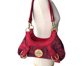 May include: Red and black Diesel handbag with gold-tone hardware. The bag features a repeating pattern and the text "1978 Diesel". The bag has two handles and a shoulder strap. The bag is displayed on a mannequin.