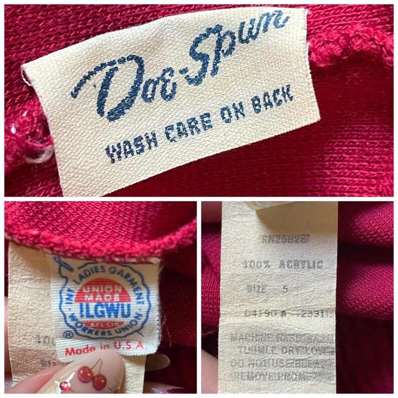 Op de afbeelding: Close-up van een rood kledingstuk met meerdere labels. E&eacute;n label luidt "Dor-Spun" en "WASH CARE ON BACK". Een ander label toont "ILGWU" en "Made in U.S.A.". Een derde label geeft 100% acryl en maat 5 aan.