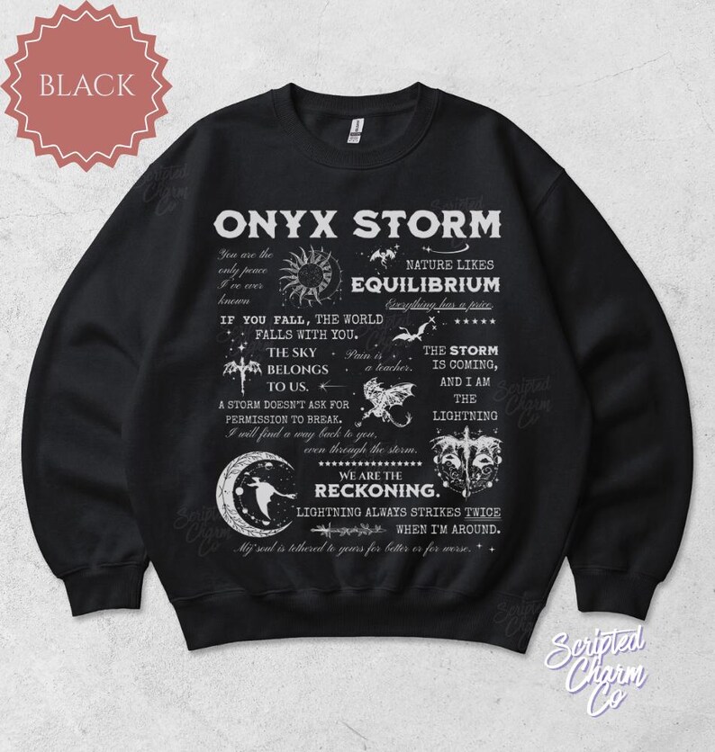 May include: Black Onyx Storm sweatshirt with white text and graphics. The design includes phrases like "Equilibrium," "The Sky Belongs to Us," and "We Are the Reckoning." A celestial theme with moons, stars, and lightning bolts.