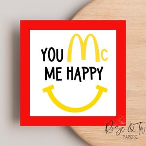 May include: Red card with a white border and a yellow M inside a red circle. The text "You Mc Me Happy" is written in black letters. A yellow smiley face is below the text.