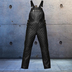 Op de afbeelding: Zwarte leren overall met een gewatteerd ruitpatroon. De tuinbroek heeft verstelbare bandjes, een borstzak met ritssluiting en metalen hardware. De broek heeft een gewatteerd ontwerp en is geschikt voor diverse activiteiten.