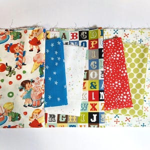 May include: A collection of fabric swatches with various patterns. Designs include children with ice cream, blue stars, white polka dots, red stars, and colorful letters. The fabrics are arranged side by side.