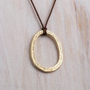 Gold Oval Pendant On A Brown Silk Necklace