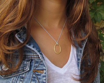 Gold Oval Pendant On A Light Blue Silk Necklace