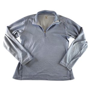 May include: A pale blue long-sleeved shirt with a quarter-zip. The shirt features a collared neckline and a mesh lining. The Patagonia logo is visible at the bottom. The shirt is made of a lightweight material, suitable for sports or casual wear.