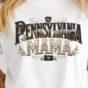 May include: A white t-shirt featuring a graphic with the text PENNSYLVANIA MAMA. The design includes a Liberty Bell, a covered bridge, a coal cart, and a small map of Pennsylvania with a heart. The lettering is filled with floral patterns.
