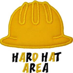 May include: Yellow hard hat with black text that reads "HARD HAT AREA".