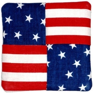 May include: A square fabric patchwork design with four sections of the American flag. The top left and bottom right sections are blue with white stars. The top right and bottom left sections are red and white stripes.