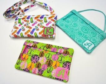 May include: Three small fabric bags with personalized initials. The bags have different patterns: flip flops, peace signs, and swirls. The bags have a strap or handle for carrying.
