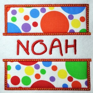 May include: A white fabric with a red embroidered border and the name "NOAH" in red thread. The fabric has two rectangular sections with a colourful polka dot pattern.